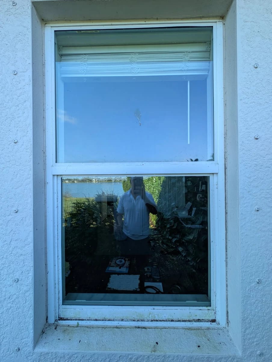 Sliding window before LUX cleaning — spotted glass and a dirty, stained sill